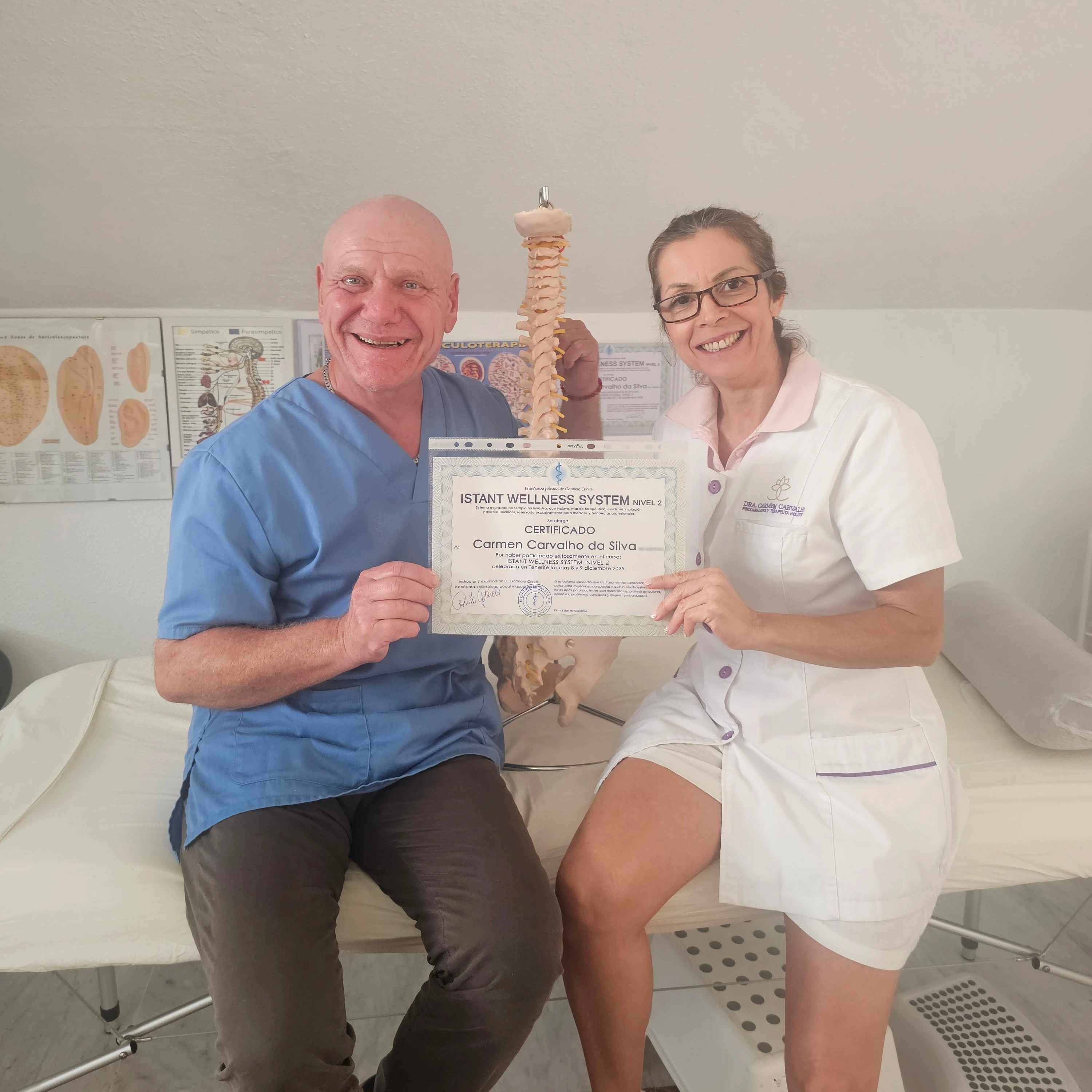 Carmem recibiendo el certificado de acupuntura clínica junto a su formador — símbolo de la acupuntura y la terapia manual
